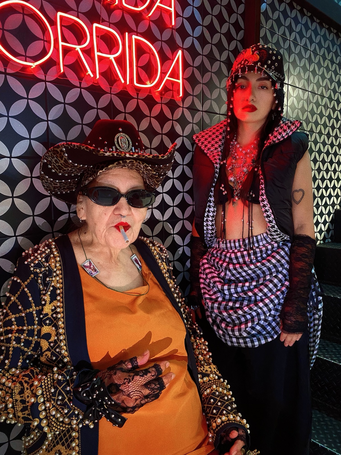 Dixy y su abuela con looks de capas, joyería y sombreros.
