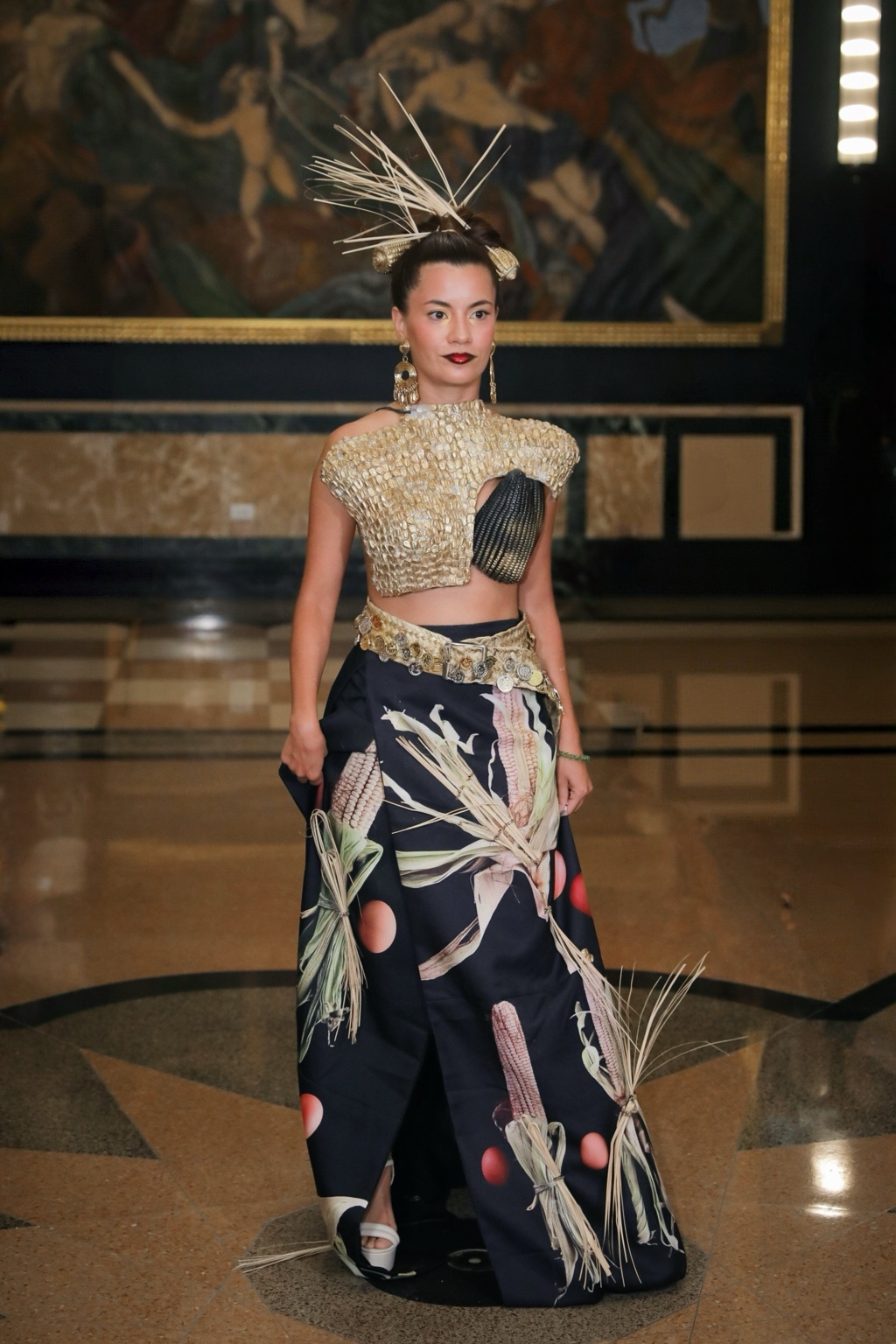 Look de la colección con corsetería dorada, maíz y un tocado de fibras.