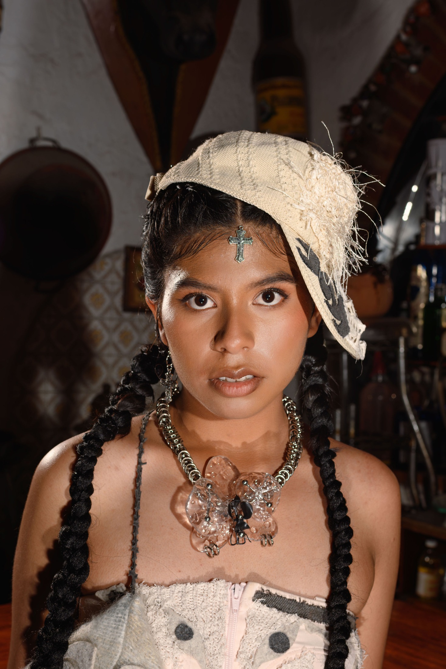 Retrato cercano con tocado blanco y collares.